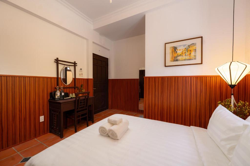 Postel nebo postele na pokoji v ubytování Hoianese Heritage Hotel - Truly Hoi An