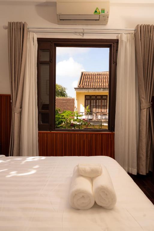 Postel nebo postele na pokoji v ubytování Hoianese Heritage Hotel - Truly Hoi An