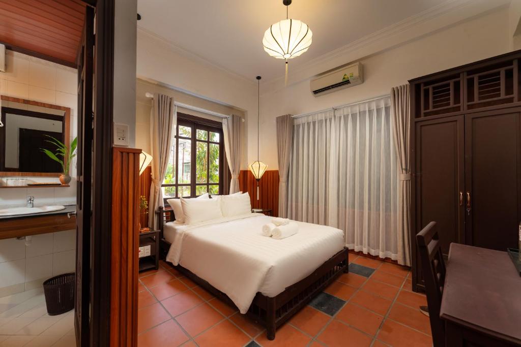 Postel nebo postele na pokoji v ubytování Hoianese Heritage Hotel - Truly Hoi An