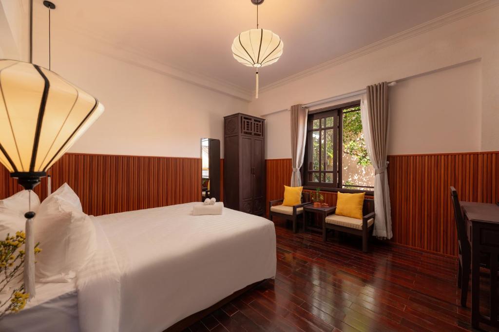 Postel nebo postele na pokoji v ubytování Hoianese Heritage Hotel - Truly Hoi An