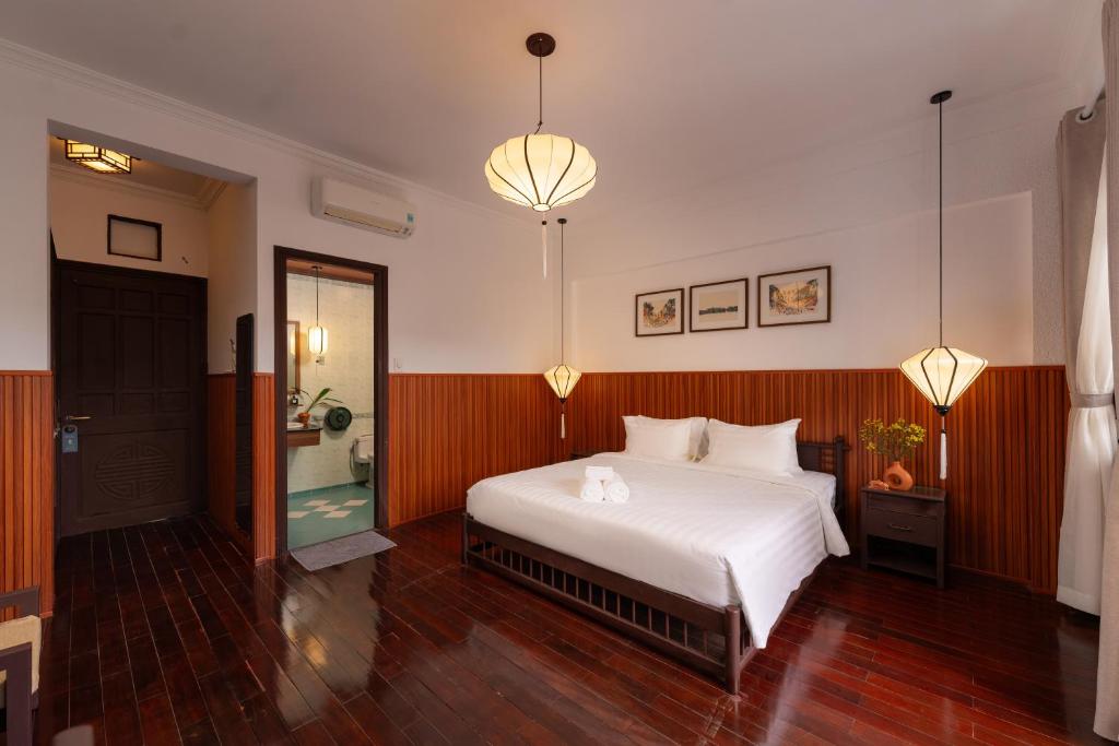 Postel nebo postele na pokoji v ubytování Hoianese Heritage Hotel - Truly Hoi An
