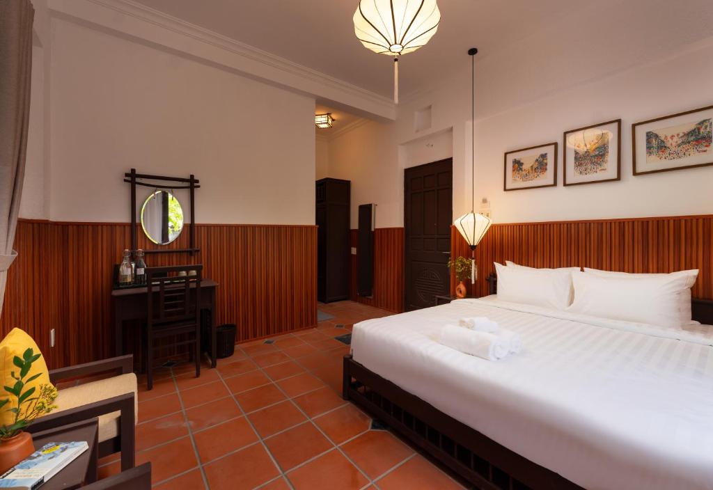 Postel nebo postele na pokoji v ubytování Hoianese Heritage Hotel - Truly Hoi An