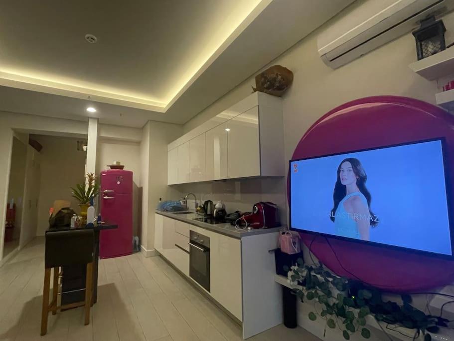 cocina con TV de pantalla plana grande en la pared en Fully furnished , luxury, site with Pool en Ankara