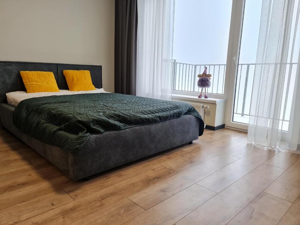 a bedroom with a bed with yellow pillows on it at Studio apartamentas su balkonu in Vilnius