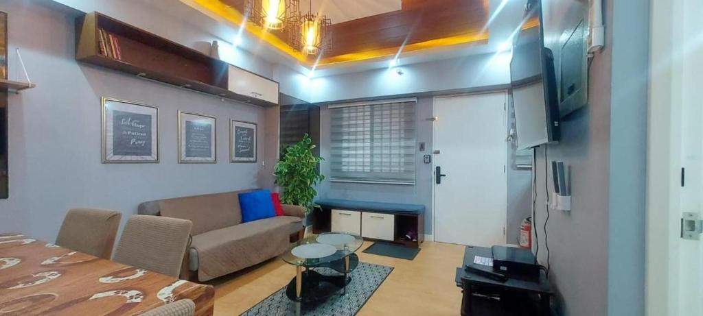 a living room with a bed and a couch at Cozy and Big Unit in Torre de Manila in Manila
