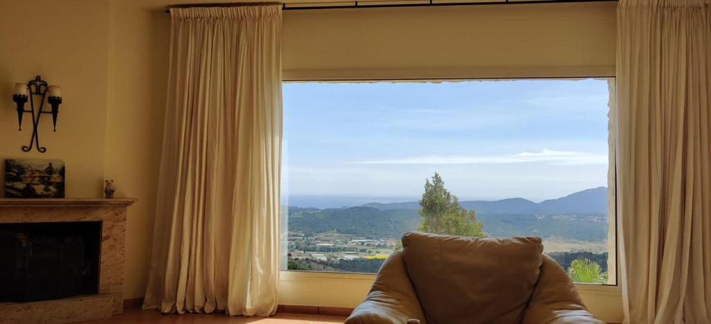 sala de estar con ventana grande y sofá en Villa Mas Nou, en Castillo de Aro