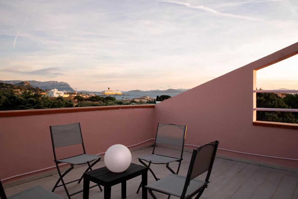 4 sillas y mesa en un balcón con ventana en Casa Marisa by Wonderful Italy, en Golfo Aranci