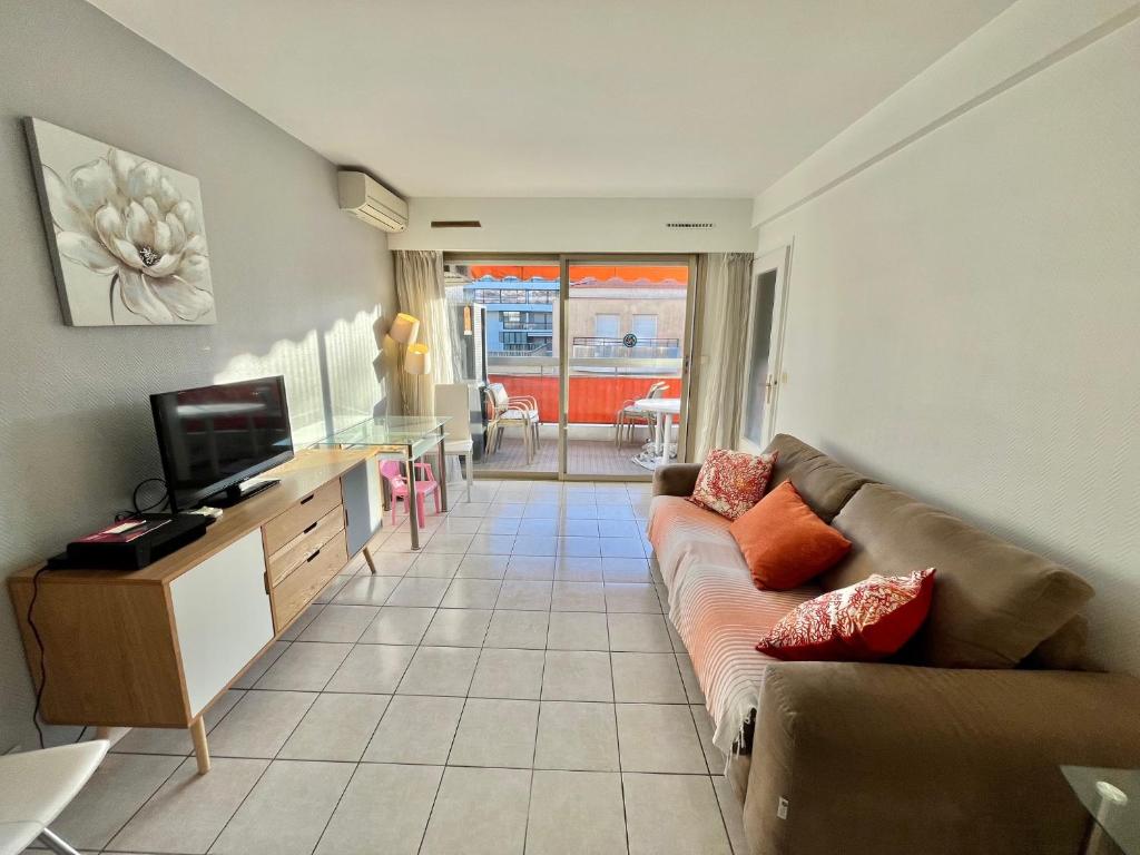 un salon avec un canapé et une télévision dans l'établissement Kent studio by Welcome to Cannes, à Cannes