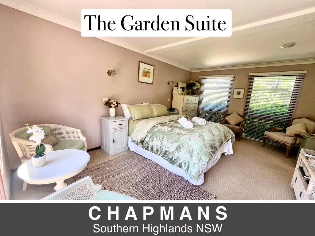 ein Schlafzimmer mit einem Bett, einem Stuhl und einem Tisch in der Unterkunft French Provincial The Garden Suite at Chapmans incl Breakfast & Golf in Moss Vale