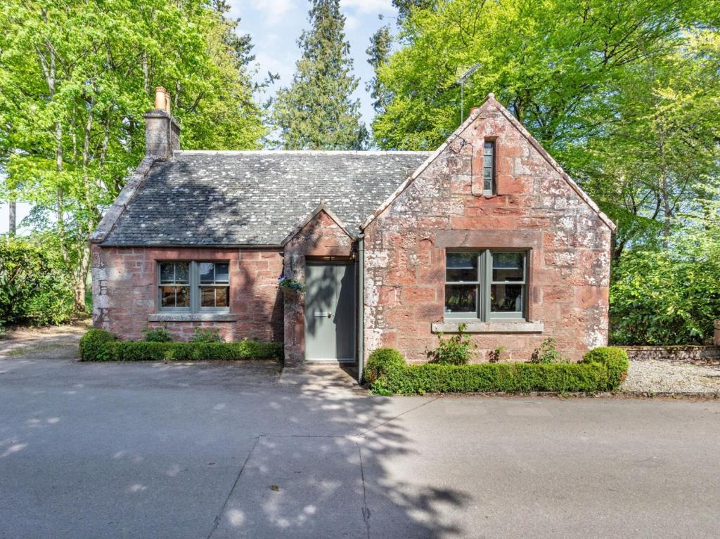 a brick house with a garage in a driveway at 2 Bed in Fettercairn 86758 in Fettercairn