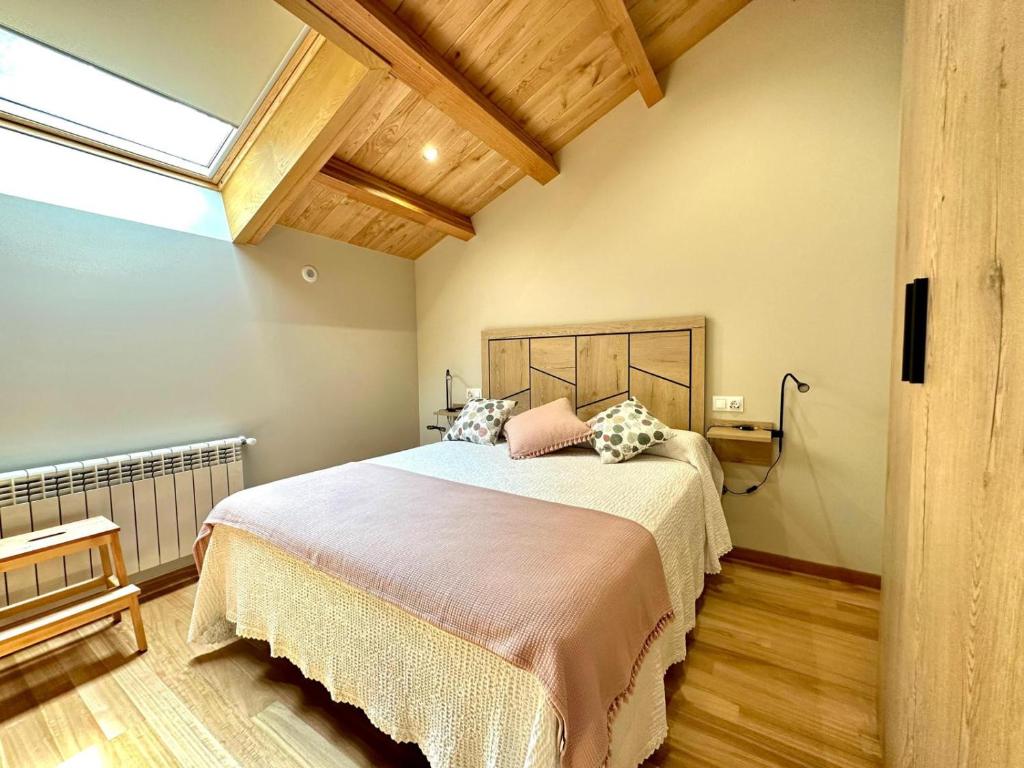 1 dormitorio con 1 cama grande y tragaluz en 29E01 Casa Courego - Vegadeo, en Vegadeo
