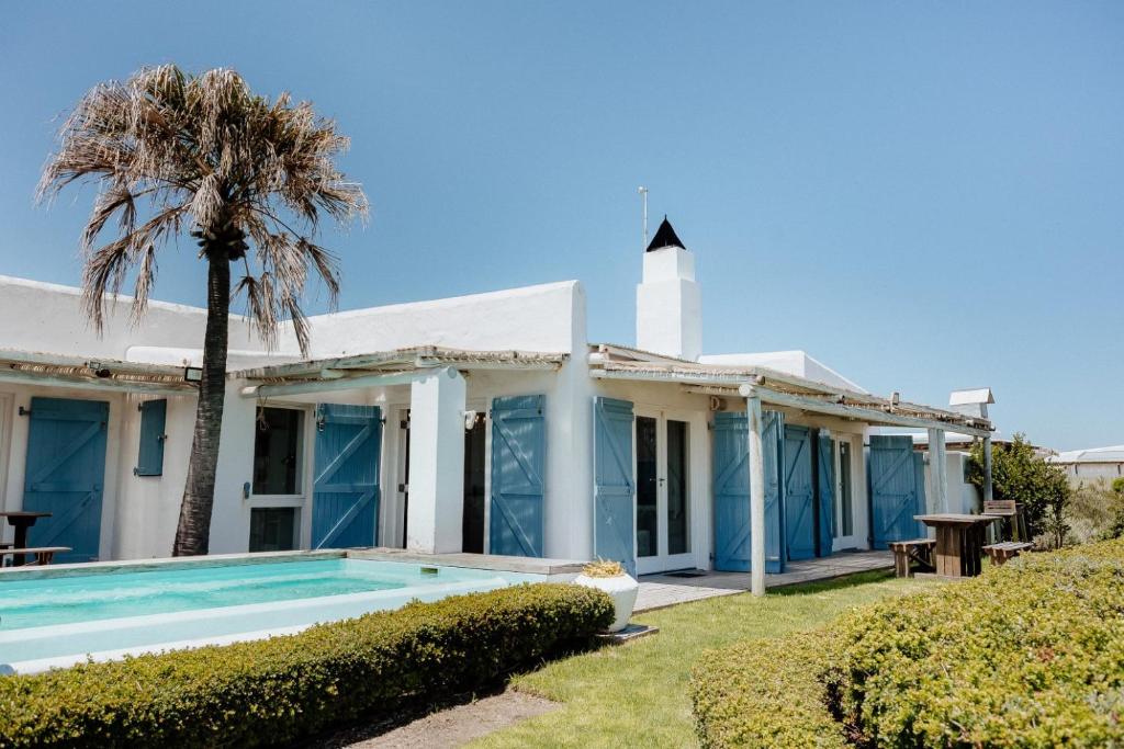 a house with a swimming pool and a lighthouse at Djis Tjil in Paternoster