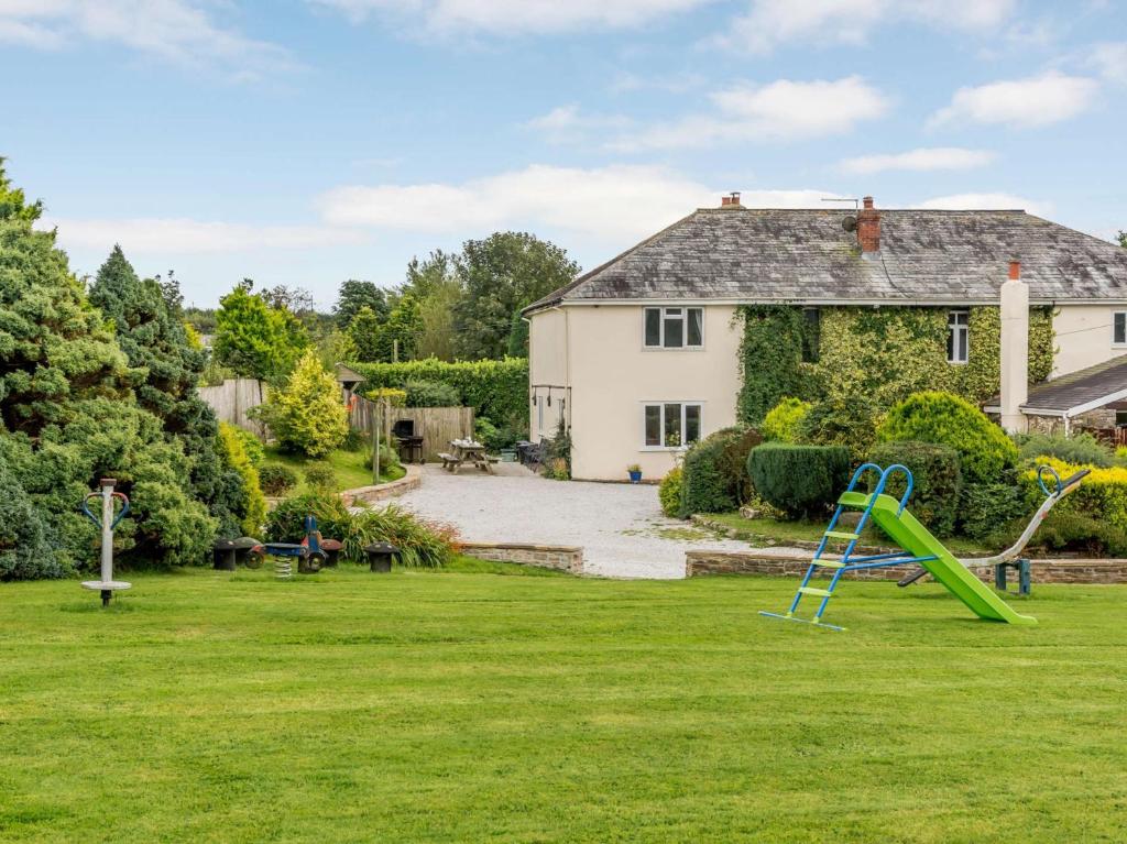 a yard with a playground in front of a house at 8 Bed in Clovelly 85428 in Woolfardisworthy