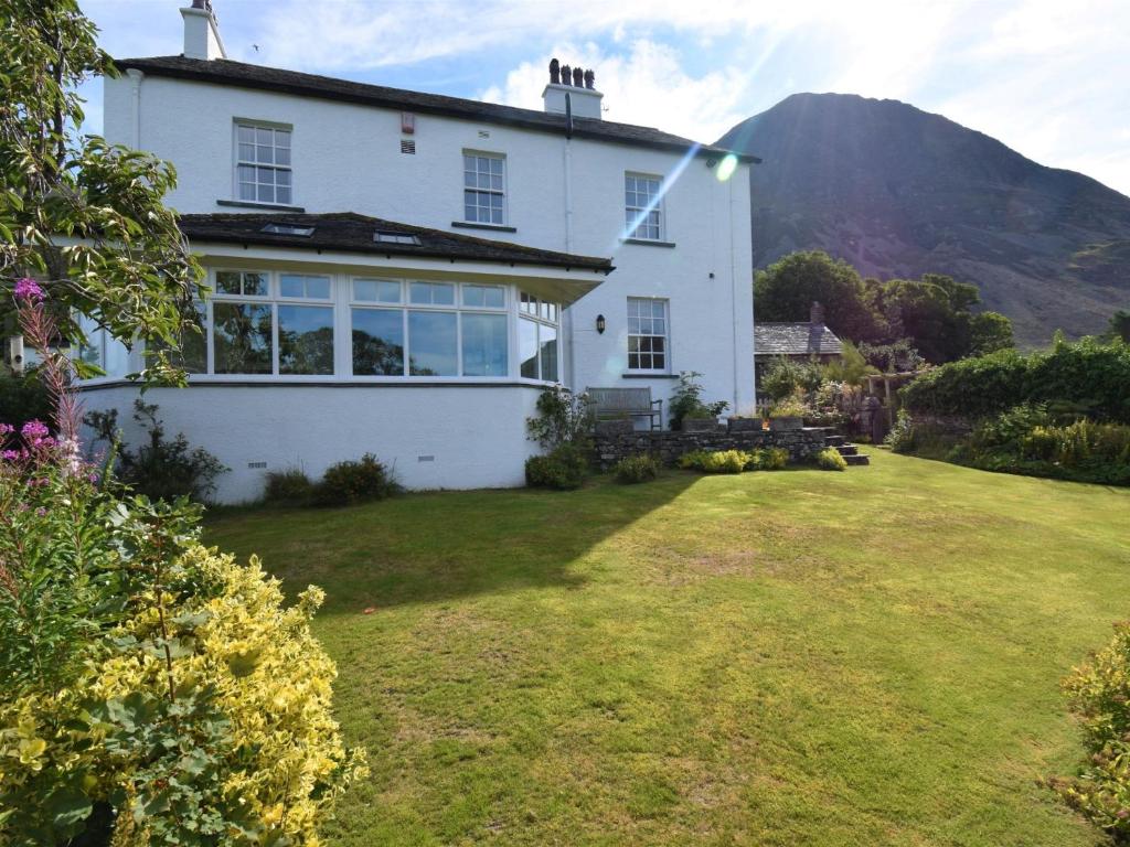 a white house with a hill in the background at 4 Bed in Buttermere 85979 in Buttermere