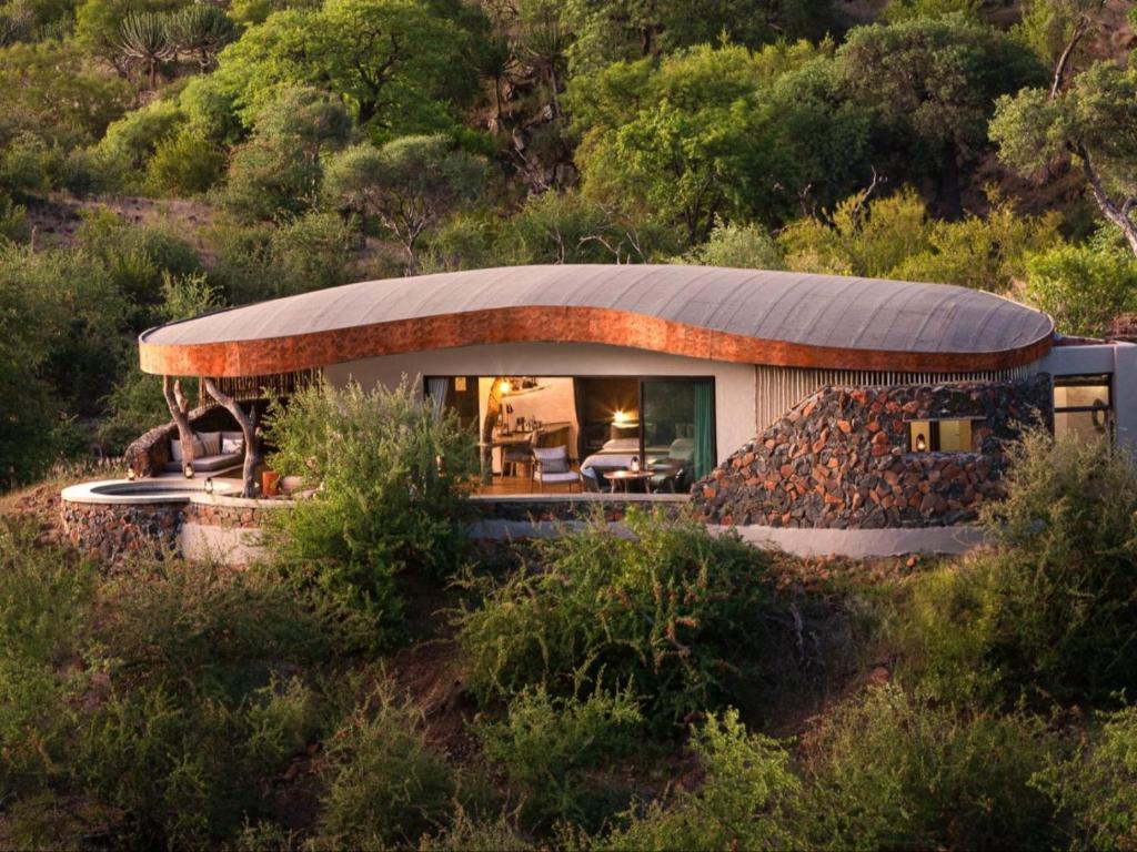 una casa circolare con tetto curvo su una collina di Euphorbia Mashatu a Lentswelemoriti