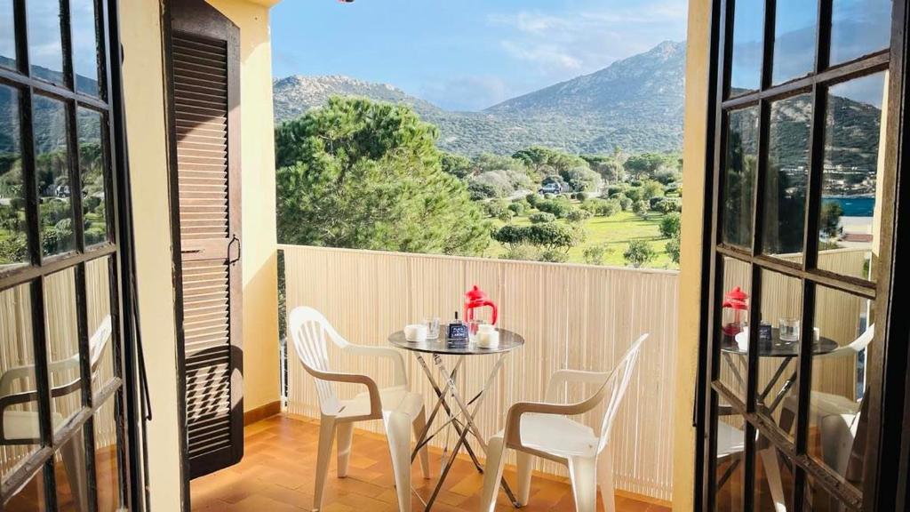 une table et des chaises sur un balcon avec vue dans l'établissement Studio PORTO 39 Lumio, à Lumio