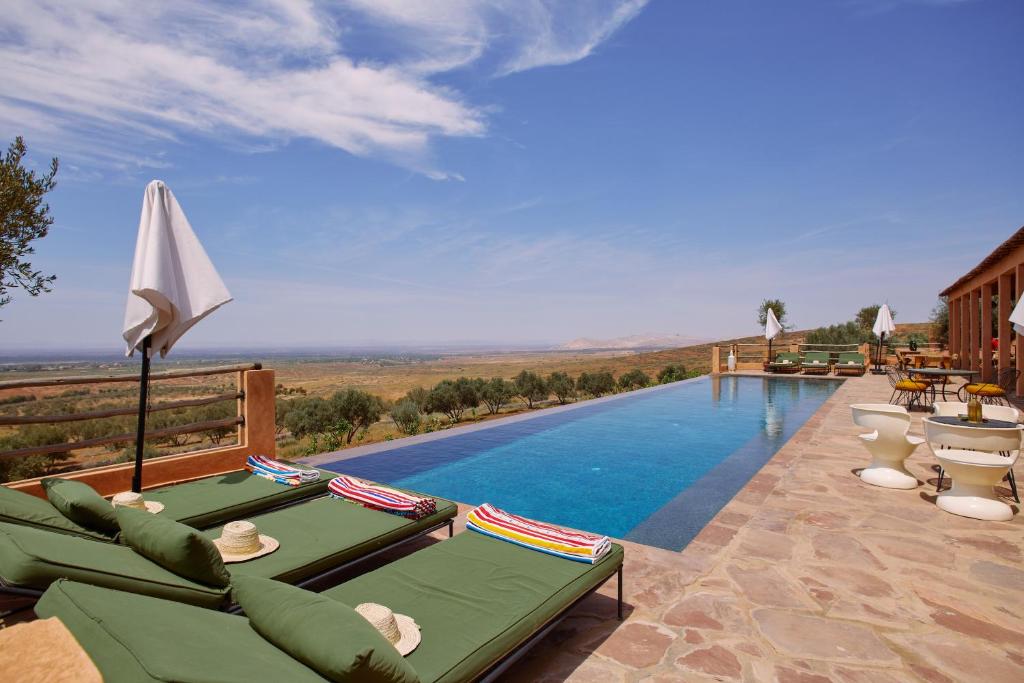 a pool with chaise lounge chairs and a swimming pool at Dar Imiri in Ourika