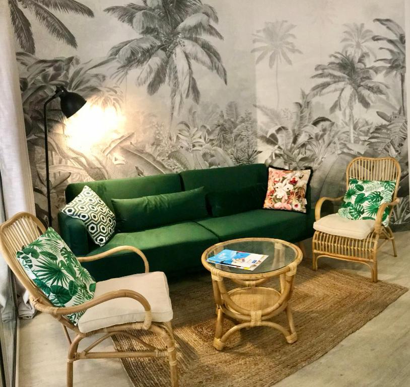 a living room with a green couch and chairs at STEPS TO THE BEACH apart in CANNES with Parking in Cannes