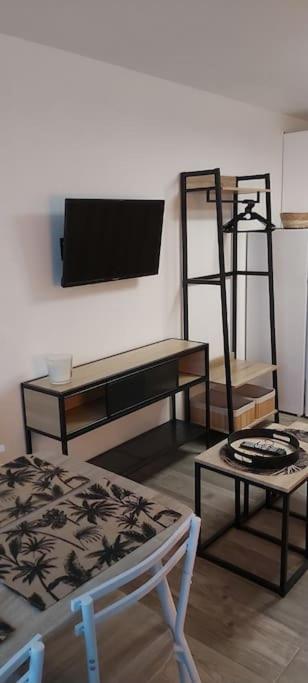 a room with shelves and a table and a chair at Studio rénové 200 m de la plage avec parking privé in Cap d&#39;Agde