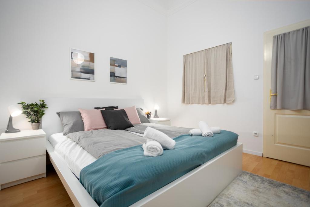 - une chambre blanche dotée d'un grand lit avec des draps bleus dans l'établissement Beautiful large F27 apartman, à Budapest