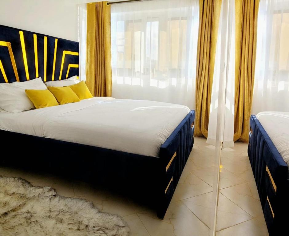 a bedroom with a bed with yellow pillows and a window at Newly Furnished 1-bedroom in Nairobi