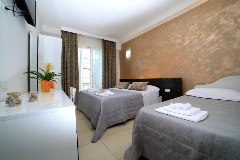 a hotel room with two beds and a window at Palazzo Greco B&B in Porto Cesareo
