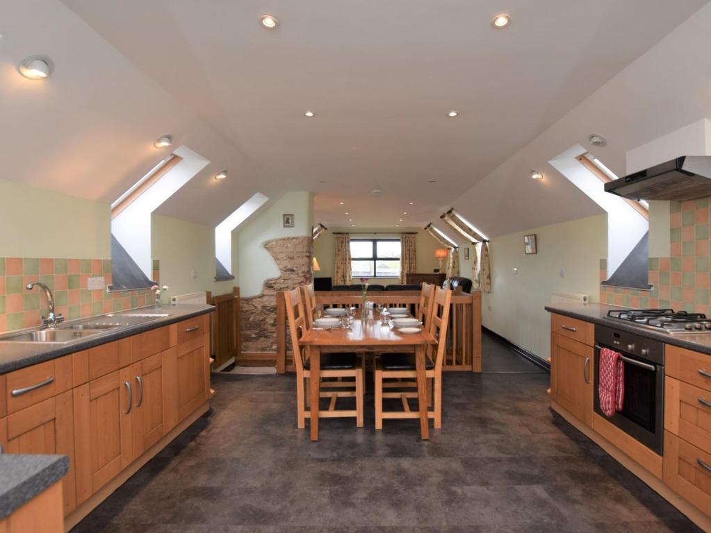 2 Bed in Exmoor 83062 في Challacombe: مطبخ مع طاولة خشبية وغرفة طعام