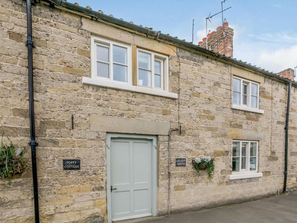 a brick building with a white door and windows at 3 Bed in Helmsley 82891 in Helmsley