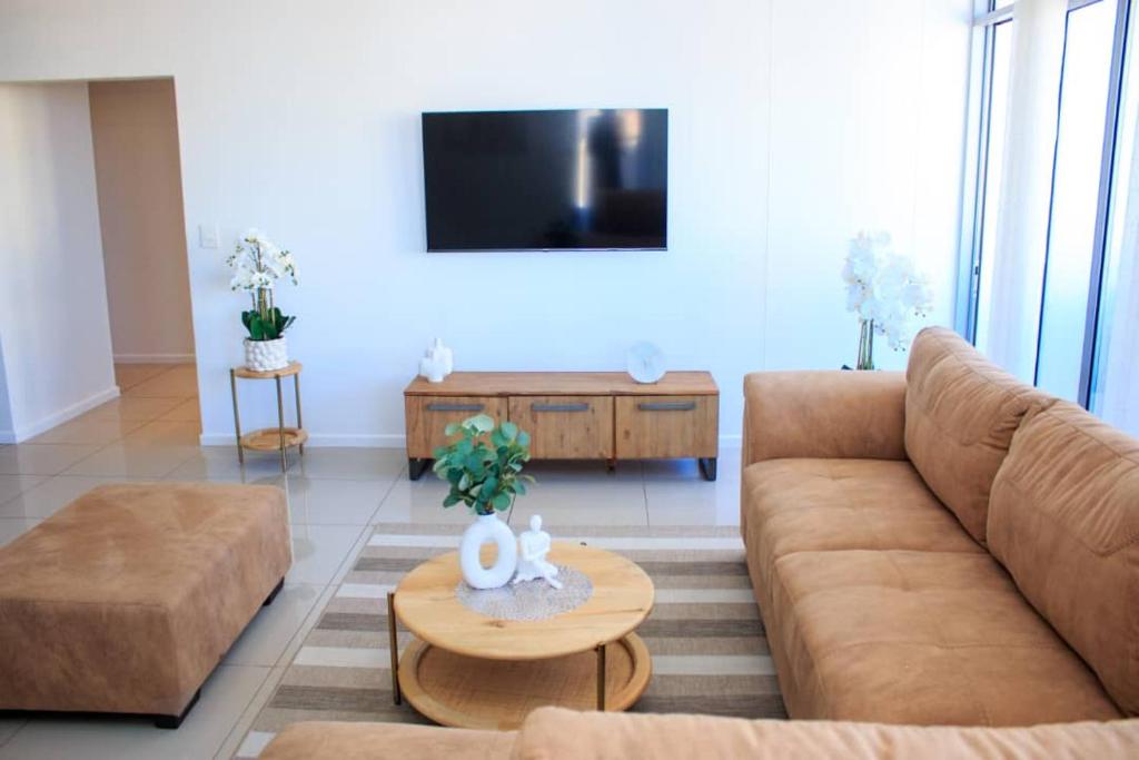 uma sala de estar com um sofá e uma mesa em Urban Oasis Apartments at Freedom Plaza em Windhoek