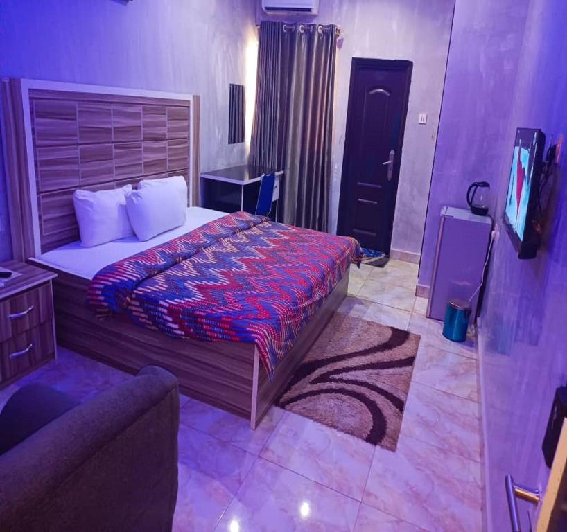 um quarto com uma cama e uma TV em Joclarif Hotel and Suites em Zaria