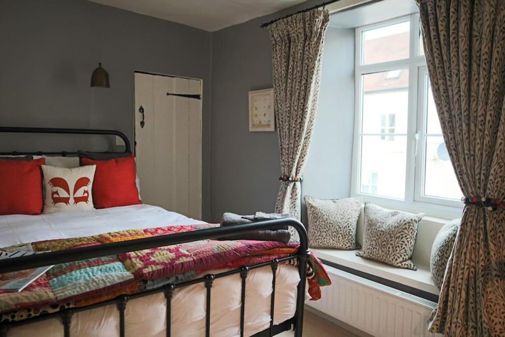 a bedroom with a bed sitting next to a window at Luxurious Town House for 4 in Desirable Ludlow - pet friendly in Ludlow