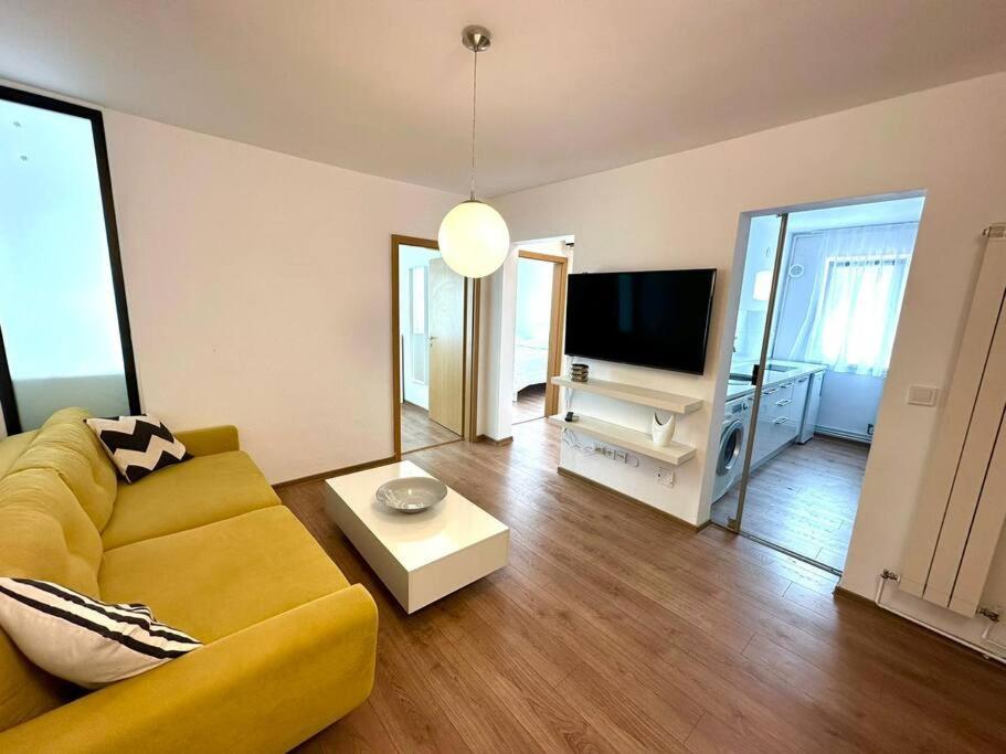 a living room with a yellow couch and a television at Carolina Residence in Alba Iulia