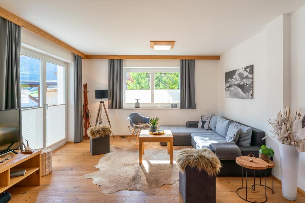 a living room with a couch and a tv at Haus Floria Top 2 in Neukirchen am Großvenediger