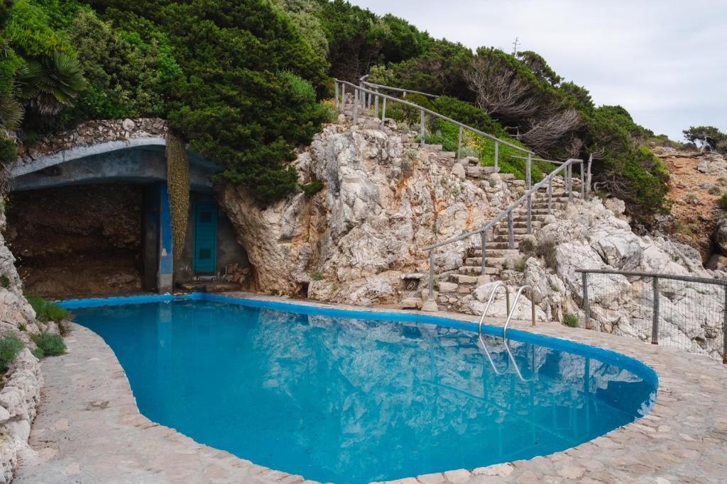 une piscine sur une falaise avec un escalier à côté de celle-ci dans l'établissement Villa Felice - Circeo, à SantʼAlfonso