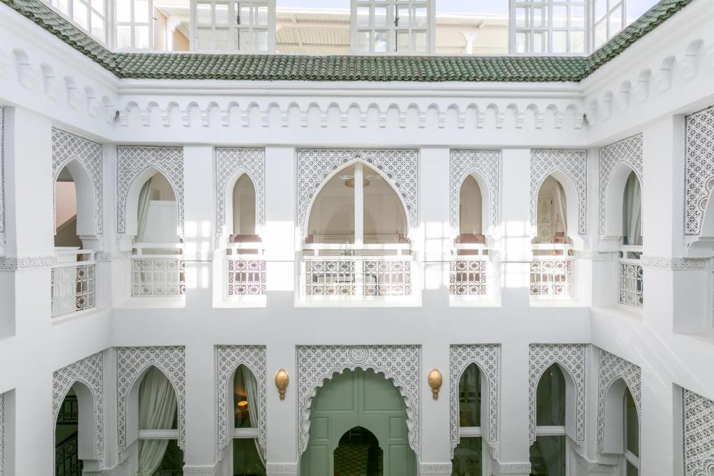 un edificio bianco con archi e porta verde di Riad Zeitoun Palace a Marrakech