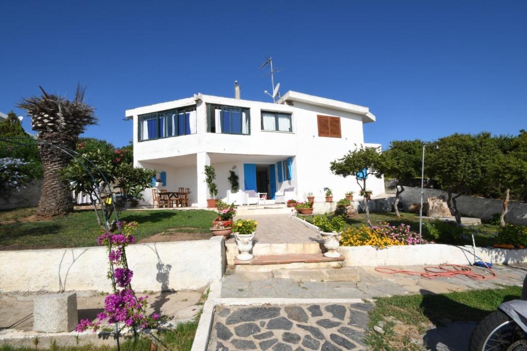 a white house with some flowers in front of it at appartamento sulla spiaggia 1 in Olbia