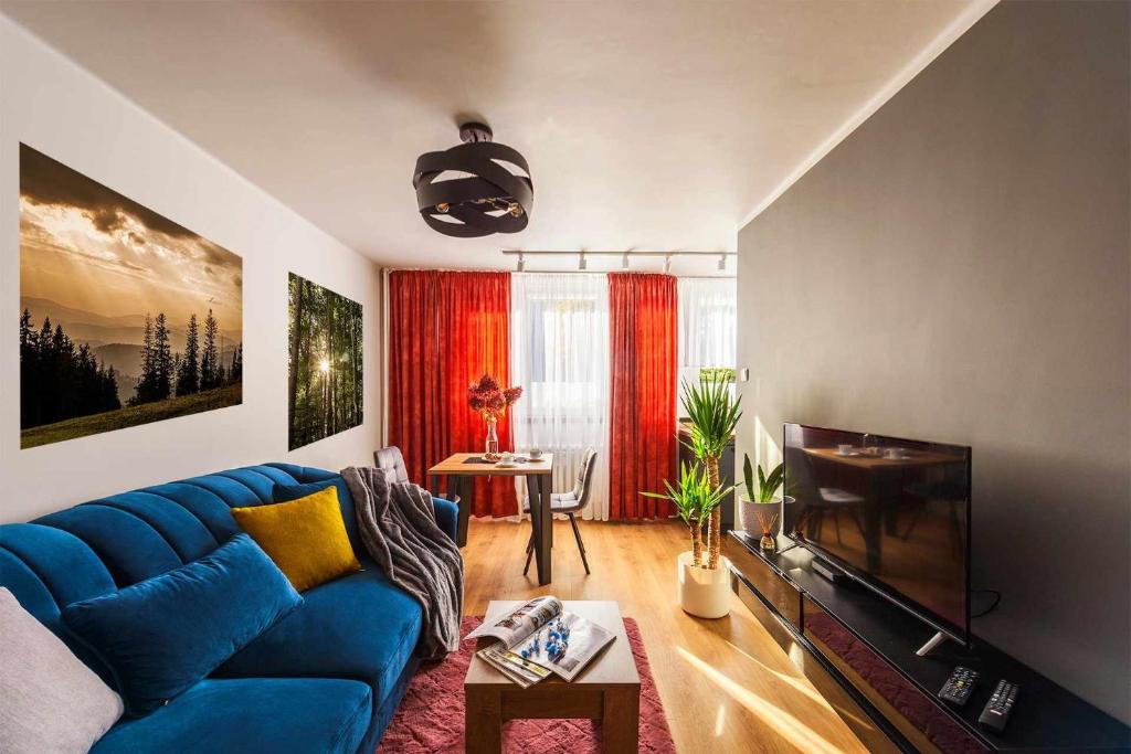 salon z niebieską kanapą i stołem w obiekcie Apartament Pod Dwójką w Bielsku Białej