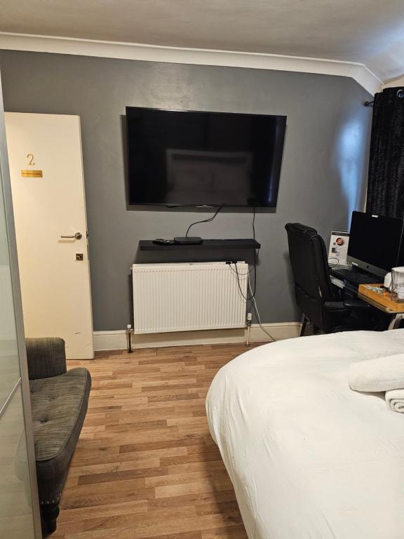 a bedroom with a bed and a flat screen tv at Umbrella Properties London Excel in London