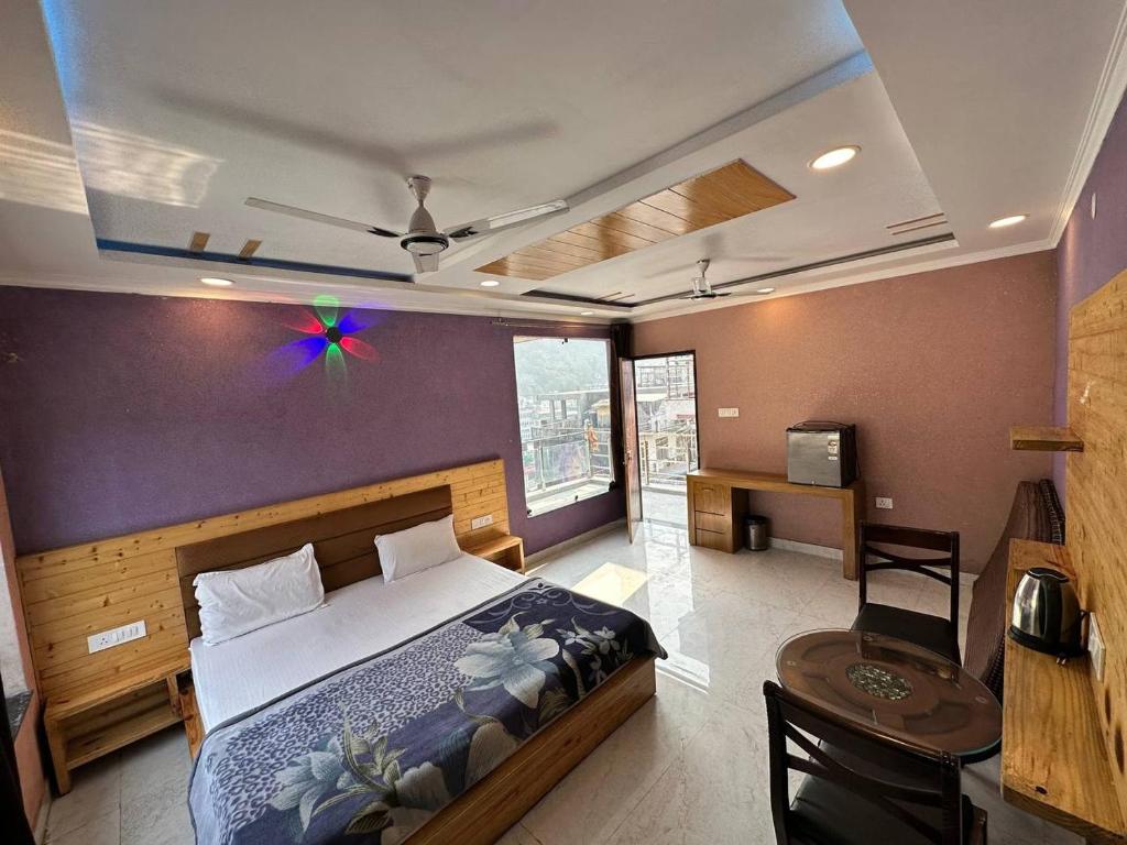 um quarto com uma cama grande, uma secretária e uma mesa em Laxman Jhula Retreat em Rishikesh
