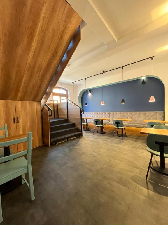 a room with a staircase and tables and chairs at Terasa in Novi Sad
