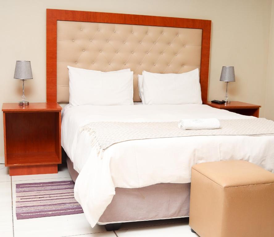 1 dormitorio con 1 cama blanca grande y cabecero grande en Mohlaletse Guest House en Ga-Matsi