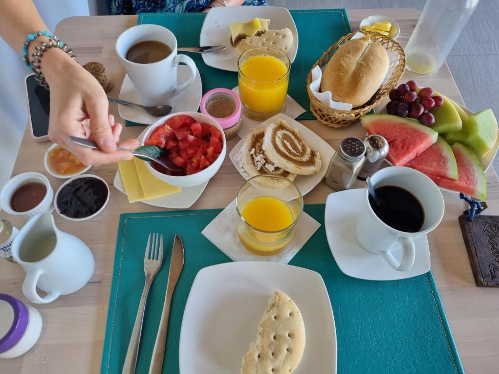 a table with a breakfast of pancakes and coffee and juice at Callihue Lodge in Santa Cruz