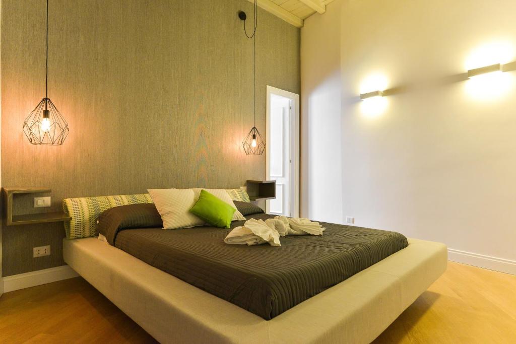 sypialnia z dużym łóżkiem i zielonymi poduszkami w obiekcie EVE Luxury Apartments Pantheon w Rzymie