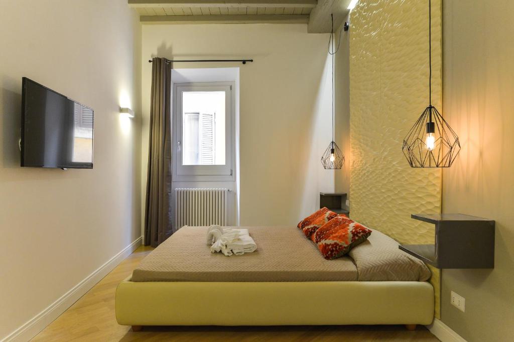 um quarto com uma cama e uma televisão na parede em EVE Luxury Apartments Pantheon em Roma
