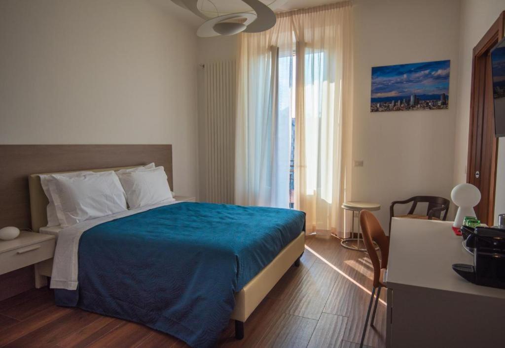 1 dormitorio con 1 cama con colcha azul en Enjoy Milano Skyline, en Milán