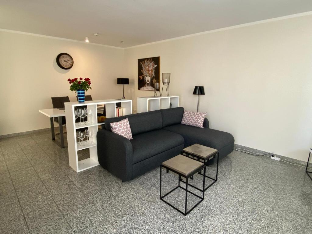 a living room with a black couch and a table at strandnahe FeWo mit Schwimmbad im Haus, a cappella 03, Binz in Binz