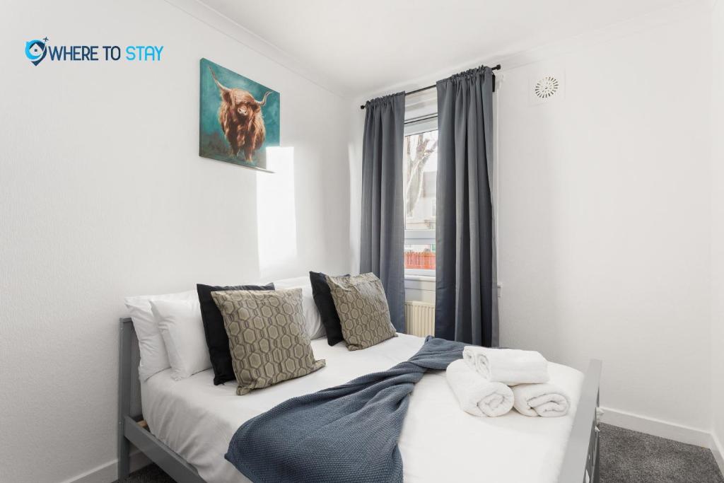 a bedroom with a white bed and a window at Secluded 2 bed apartment Edinburgh in Edinburgh
