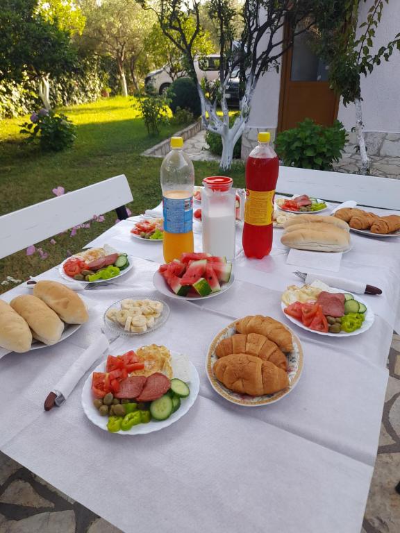 a white table with plates of food and drinks at Villa Festim Ksamil in Ksamil