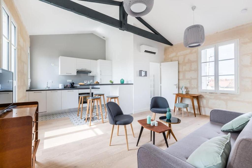 ein Wohnzimmer mit Couch und Küche in der Unterkunft Magnifiques Appartements Climatises En Plein Coeur Des Chartrons in Bordeaux