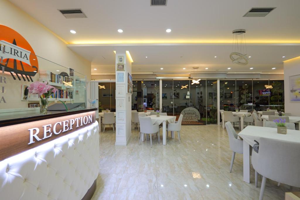 a restaurant with white tables and white chairs at Hotel Iliria in Sarandë